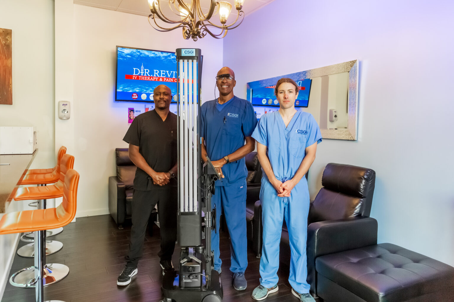 CSGI leadership team standing beside UV-C disinfection equipment